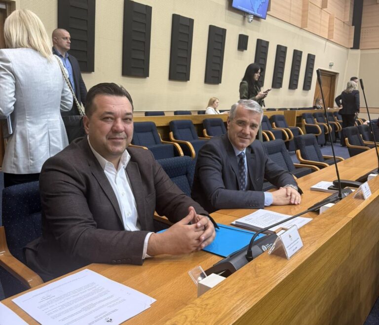 Zabrinuta medicinska sestra drži stetoskop u praznom bolničkom hodniku, ilustrujući problem malih plata i odlaska kadra u inostranstvo.