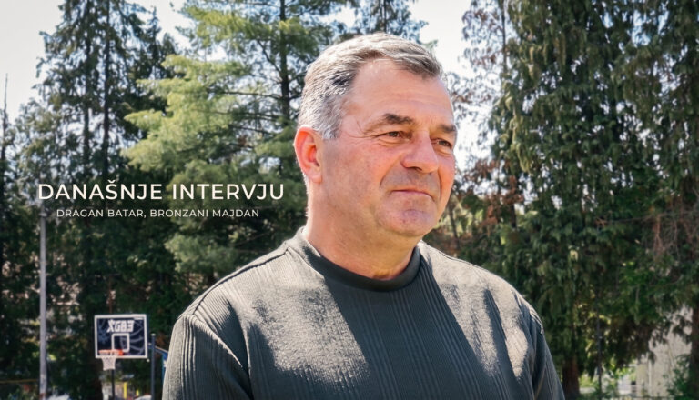Portret Dragana Batara tokom intervjua u Bronzanom Majdanu, u pozadini drveće i sportski teren.