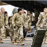 Američka vojska i vojna oprema u bazi u Njemačkoj, američka zastava u pozadini, ilustracija za povlačenje američkih trupa iz Evrope.