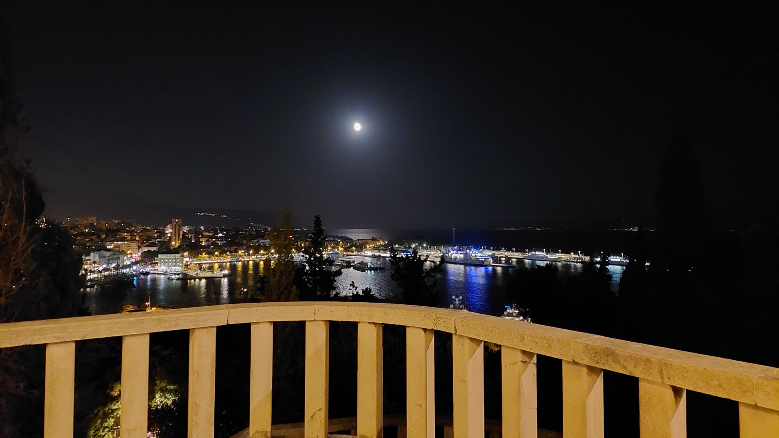 Panoramski noćni pogled na grad Split, Hrvatska, snimljen sa terase Vidilice na Marjanu, sa osvijetljenim zvonikom Svetog Duje i lukom.